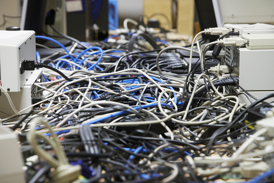 Closeup of messed wires connecting computers and printers in off